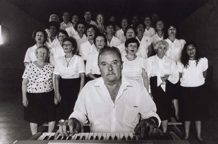Argentina, Buenos Aires: Chorus Leader at Piano with Singers Behind Him