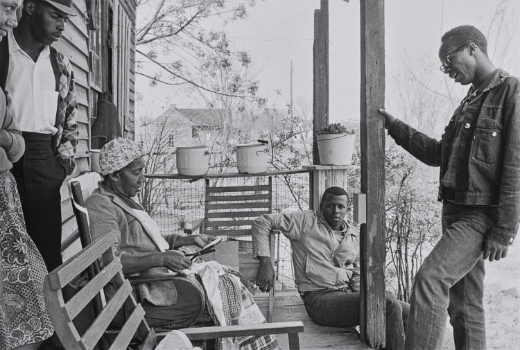 Charles Sherrod (standing at right) and Randy Battle (seated) visit a supporter in the Georgia countryside. Sherrod married there and thirty years later is still in southwest Georgia, a member of Albany City Council