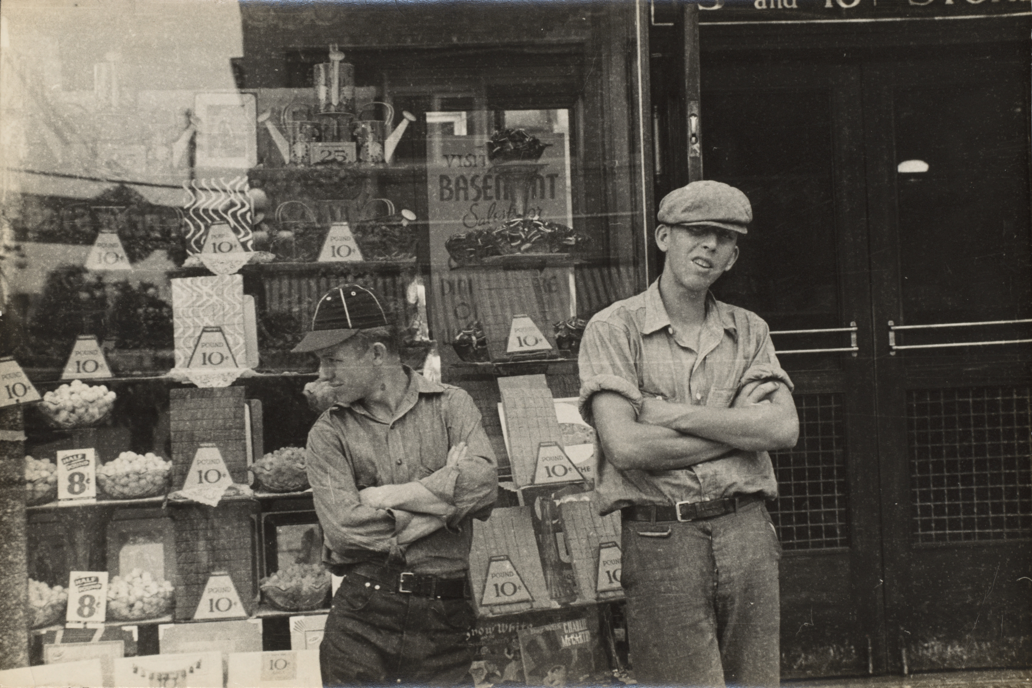 Two boys standing in front of candy store window, street scene, Circleville, Ohio