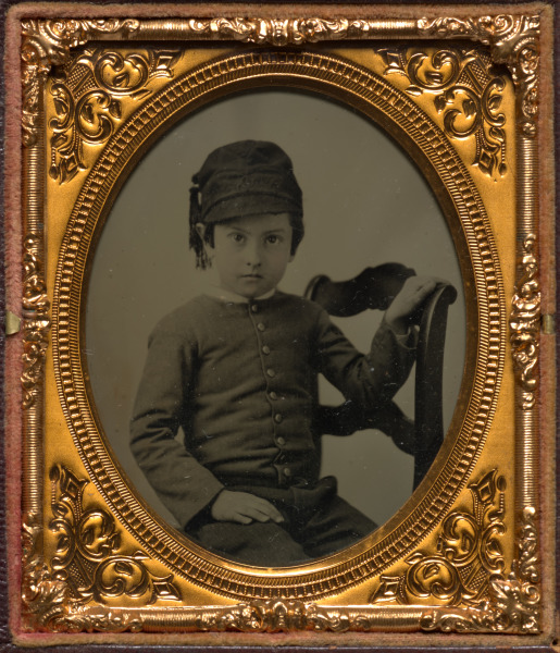Seated boy in tasseled cap
