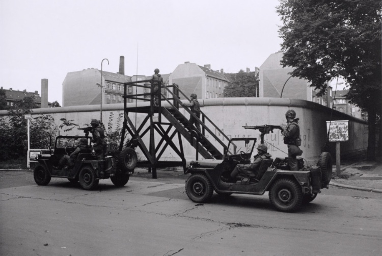 Berlin Wall patrol guards driving military vehicles