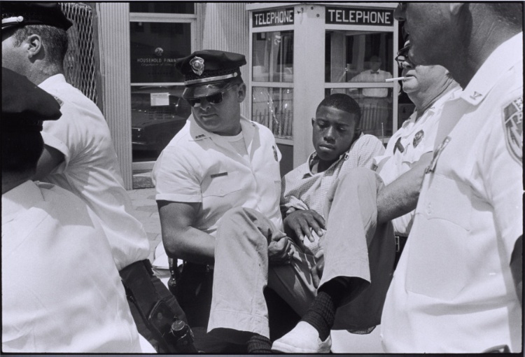 The first sit-in arrests I see and photograph are those of Eddie Brown, a former Albany gang leader, and a visitor from the North. Both have volunteered to be arrested for the photographs. The picture of Eddie Brown, calmly being carried off by the Albany police, is widely distributed as the image of the classic non-violent arrest, Georgia