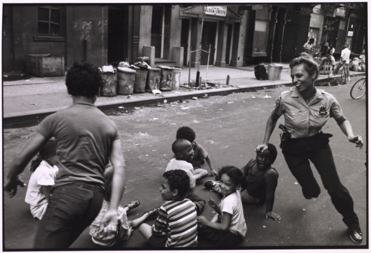 A policewoman plays games with community children. Shortly afterward, the officer became pregnant and was assigned a desk job for the period of her pregnancy, from Police Work