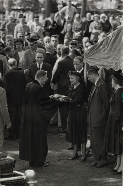 Ms. Dulles receiving a folded flag at her husband's burial service, Arlington Cemetery, Virginia