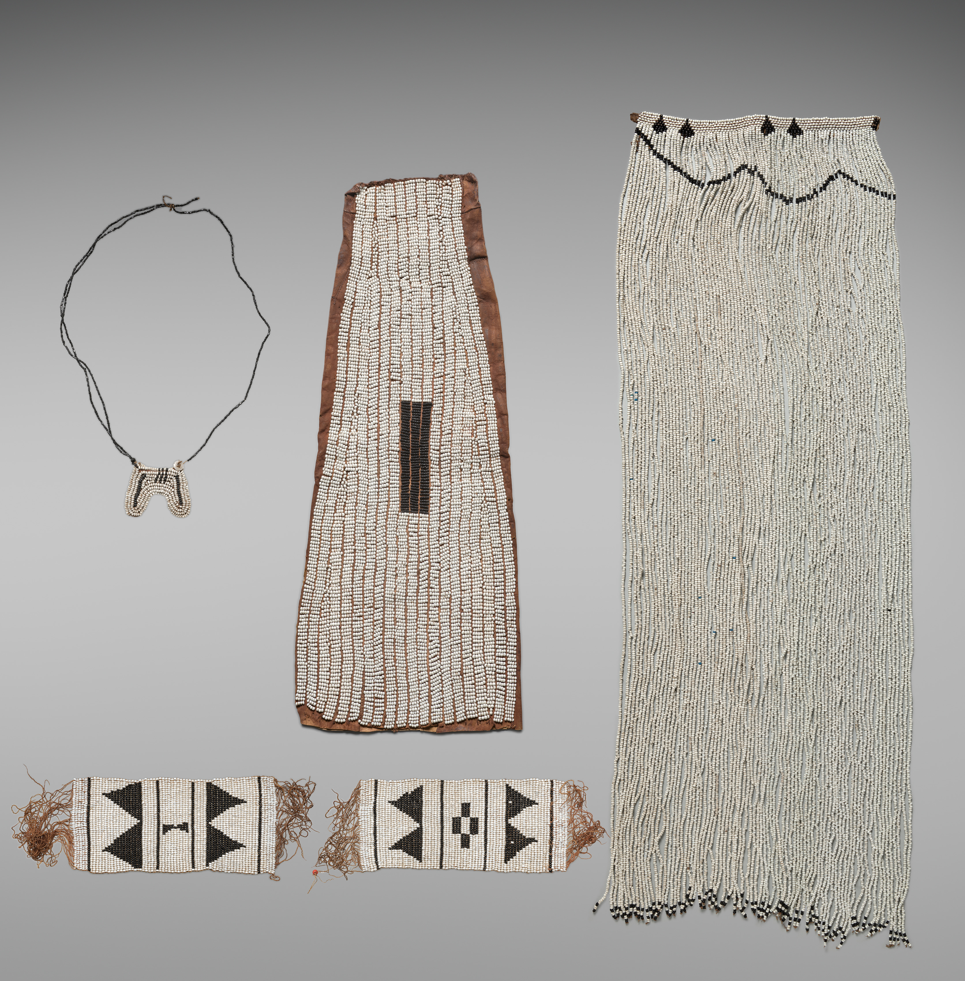 Ceremonial beadwork for a Xhosa royal woman: headdress (umnqwazi), pendant, breast cover (incebetha), pair of anklets (izitsaba)