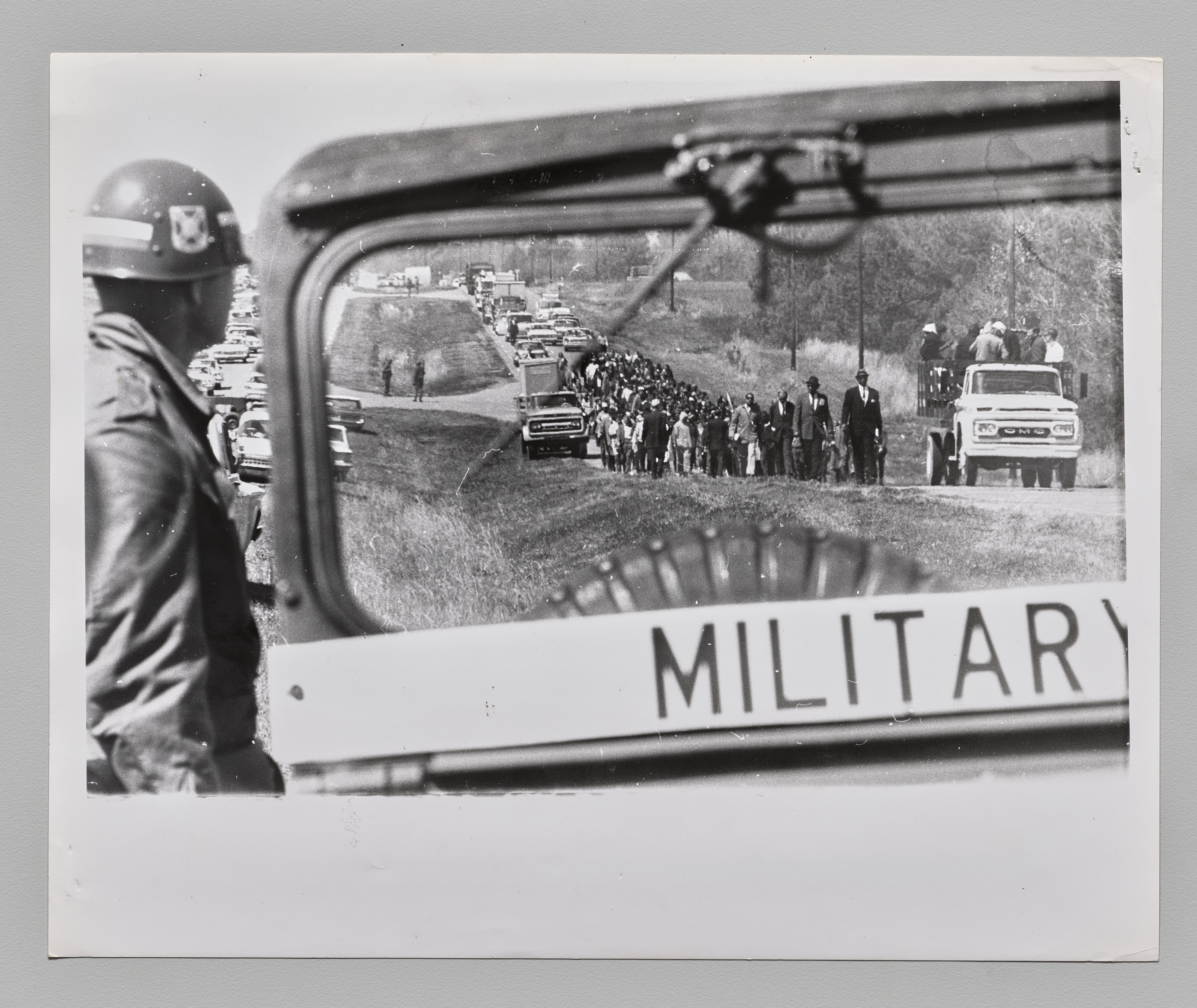 Marchers Continue Their Hike: Under the watchful eye of an Army military police, ordered out by President Johnson, civil rights marchers continue their 50-mile walk along Route 80 from Selma to Montgomery, Alabama today. Other soldiers stand guard at intersections in background, March 22, 1965