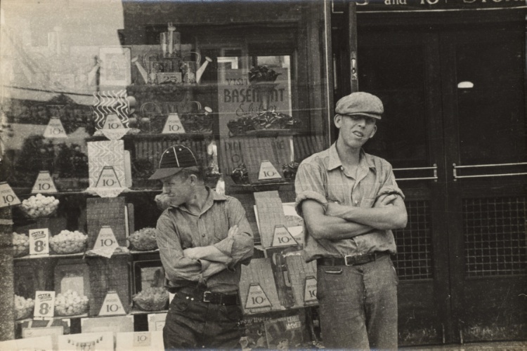 Two boys standing in front of candy store window, street scene, Circleville, Ohio