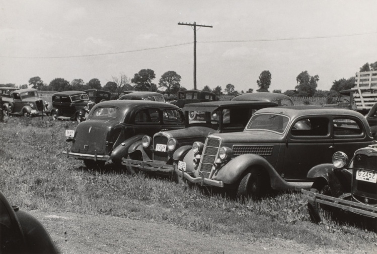 Farmers' cars parked outside of public auction, Central Ohio