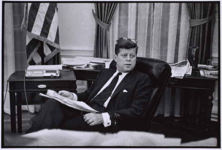 John F. Kennedy holding stack of documents