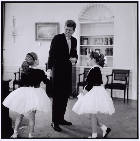 John F. Kennedy shaking hands with two girls in tutus
