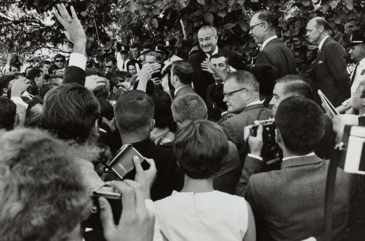 LBJ greeting a crowd of reporters and students with cameras