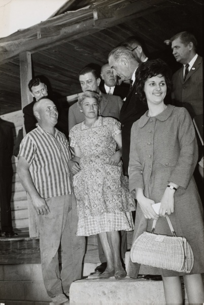 LBJ standing on a front porch with family members