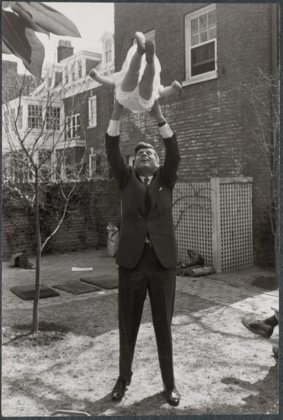 John F. Kennedy tossing daughter Caroline in the air