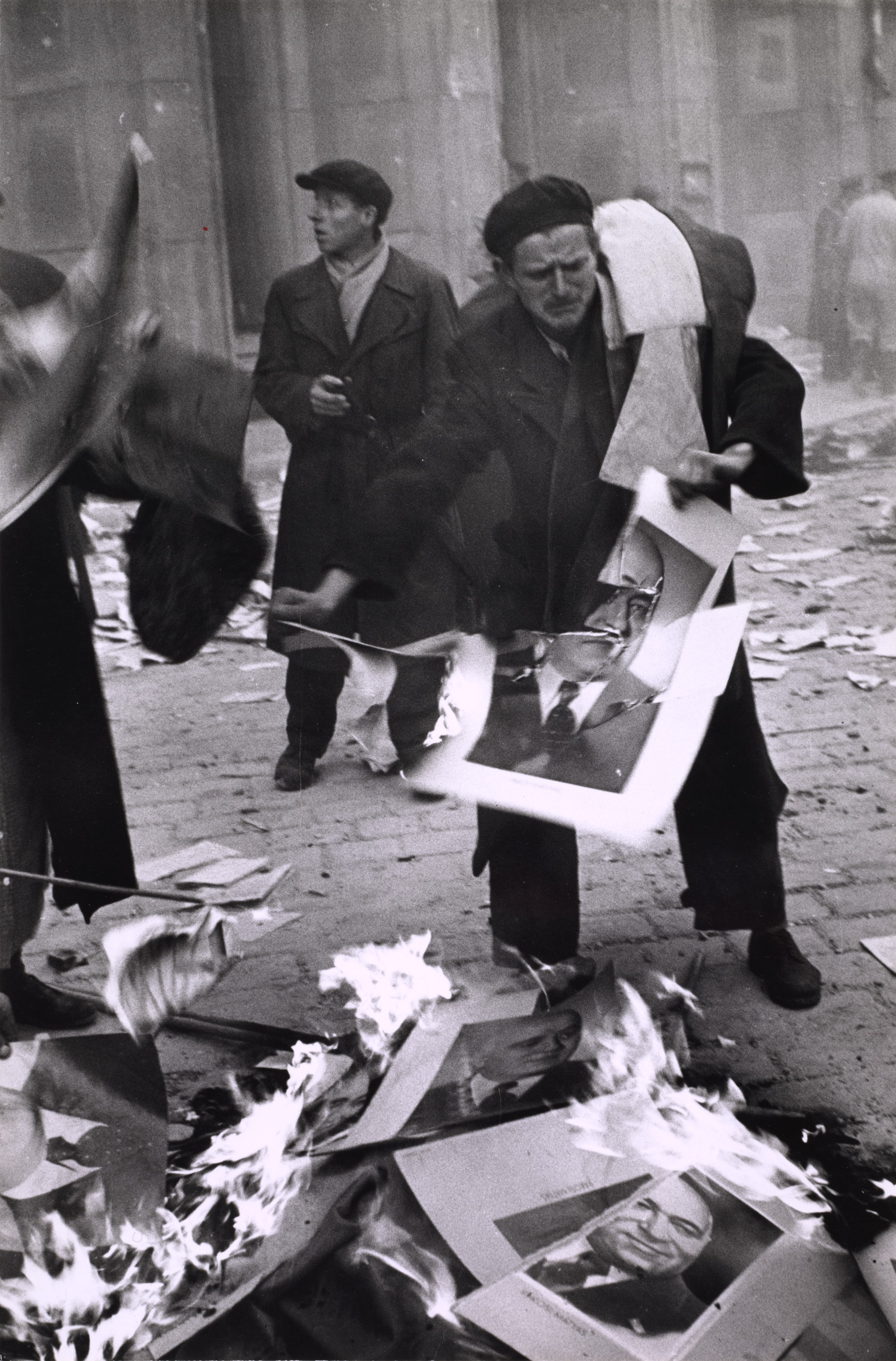 Man burning political posters in the street during revolution, Hungary