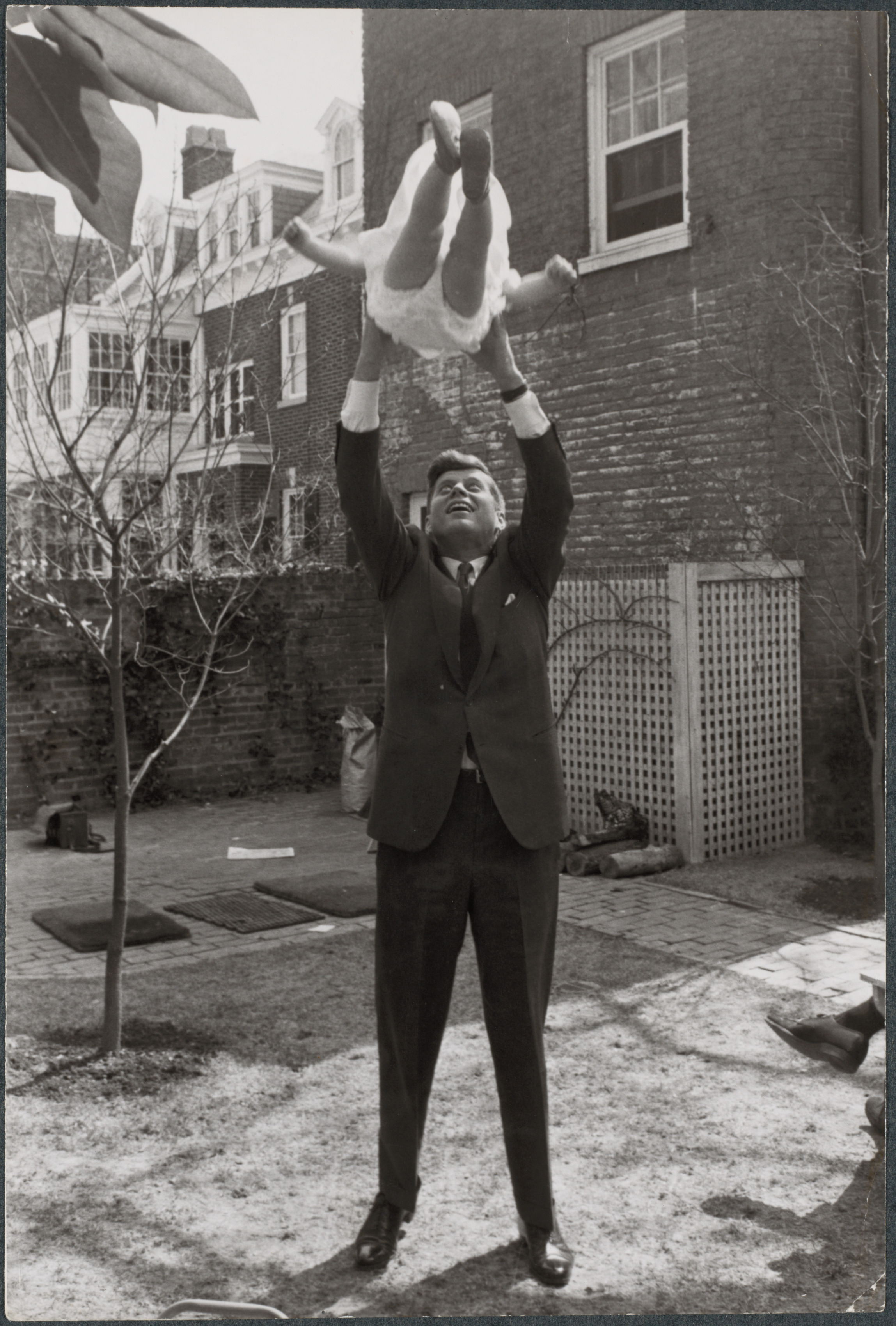 John F. Kennedy tossing daughter Caroline in the air