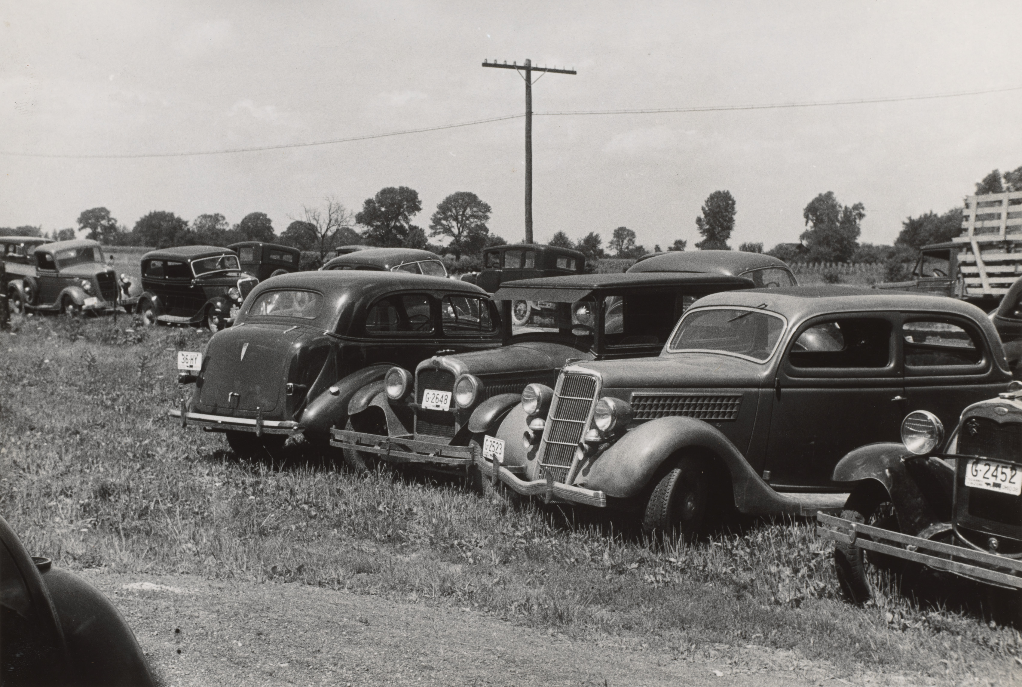 Farmers' cars parked outside of public auction, Central Ohio