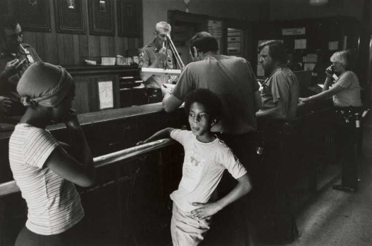A young boy who says he has been left alone comes to the precinct station house for help.  A concerned neighbor looks on